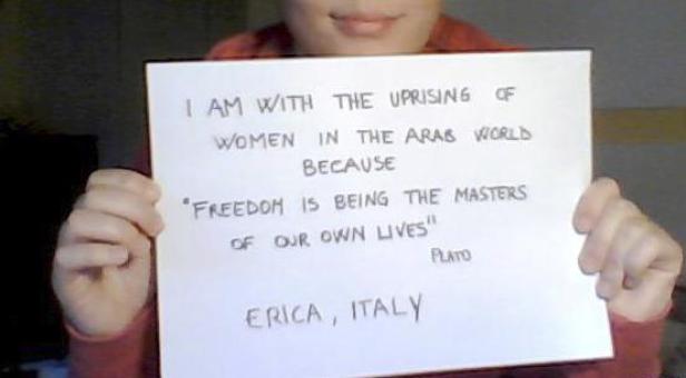Eine Person hält ein Schild mit der Aufschrift „Ich stehe an der Seite des Aufstands der Frauen in der arabischen Welt, weil ‚Freiheit bedeutet, der Meister unseres eigenen Lebens zu sein‘ – Plato. Erica, Italien.“.