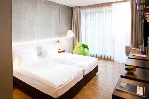 Ein Hotelzimmer mit Doppelbett, Schreibtisch und einem grünen Sitzsack.