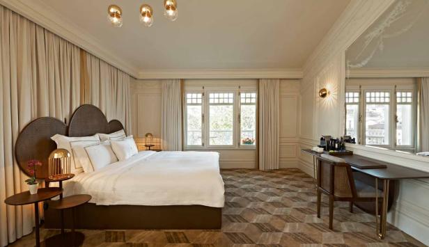 Ein helles Schlafzimmer mit einem großen Bett und einem Schreibtisch am Fenster.