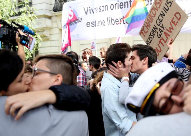 Mehrere Paare küssen sich auf einer Demonstration für LGBTQ-Rechte.