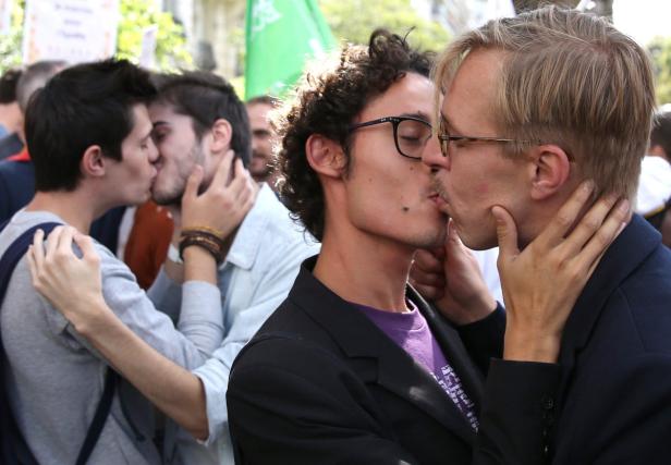 Zwei homosexuelle Paare küssen sich auf einer Demonstration.