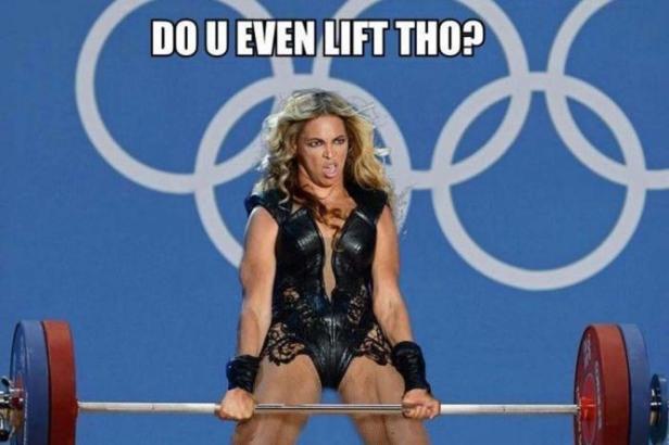 Eine Frau beim Gewichtheben vor dem Hintergrund der olympischen Ringe.