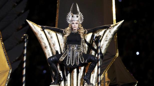 Madonna sitzt auf einem goldenen Thron mit einem auffälligen Kopfschmuck.