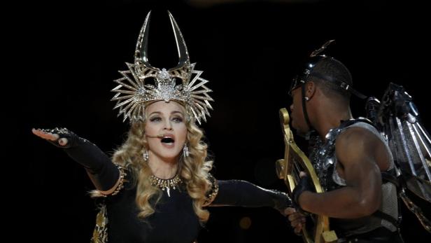 Madonna tritt mit einem Harfenisten während der Halbzeitshow des Super Bowl auf.