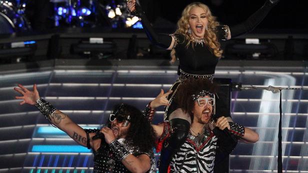 Madonna wird bei einem Auftritt von zwei Mitgliedern von LMFAO auf den Schultern getragen.