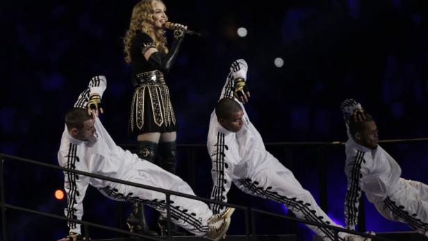 Madonna singt mit Tänzern während einer Performance.
