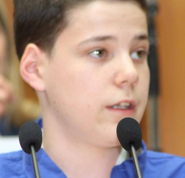 Ein junger Mann spricht in ein Mikrofon.