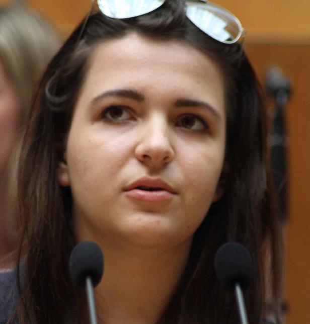 Eine junge Frau spricht vor einem Mikrofon.