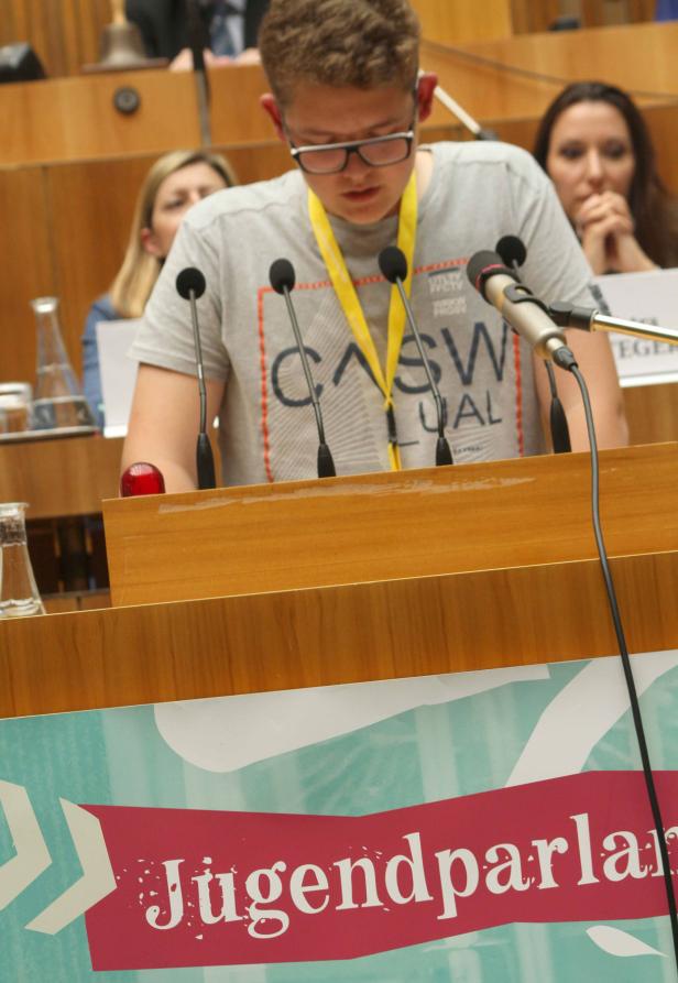Ein Jugendlicher spricht am Rednerpult während einer Sitzung des Jugendparlaments.