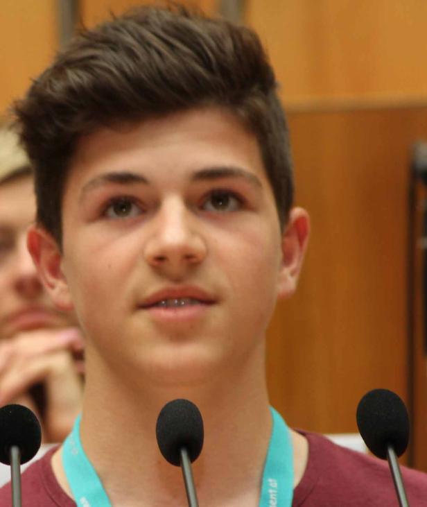 Ein junger Mann spricht vor zwei Mikrofonen.