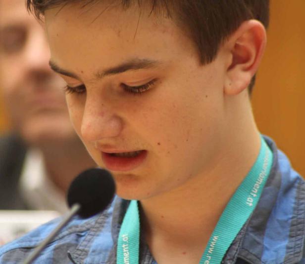 Ein junger Mann spricht in ein Mikrofon.