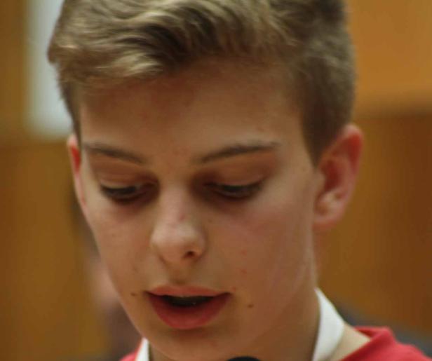 Ein junger Mann spricht in ein Mikrofon.