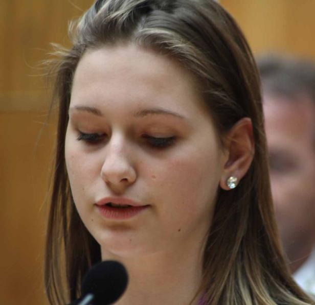 Eine junge Frau spricht vor einem Mikrofon.