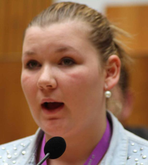 Eine junge Frau spricht in ein Mikrofon.