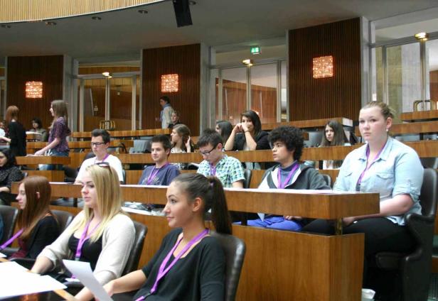 Eine Gruppe junger Leute sitzt in einem Auditorium.