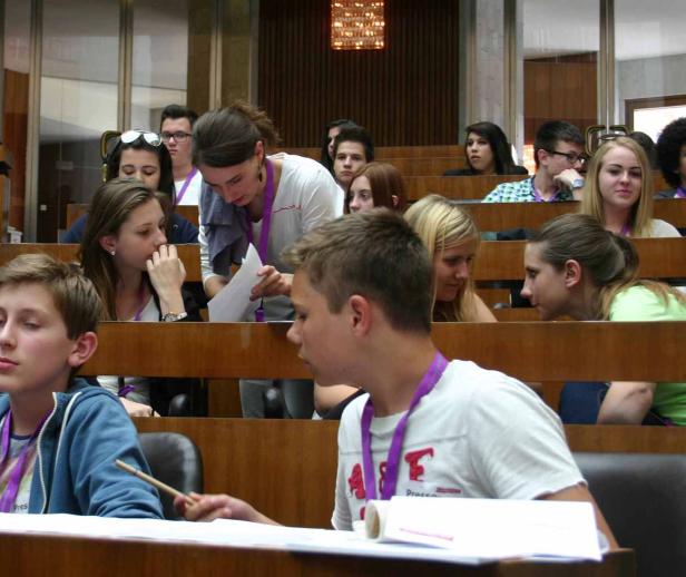 Jugendliche sitzen in einem Hörsaal während einer Veranstaltung.