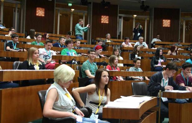 Zahlreiche Menschen sitzen in einem großen Hörsaal oder Konferenzraum.
