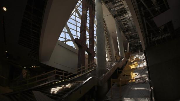 Eine Treppe in einem Gebäude mit großen Fenstern und Säulen wird renoviert.