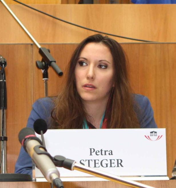 Petra Steger sitzt an einem Tisch mit Mikrofonen.