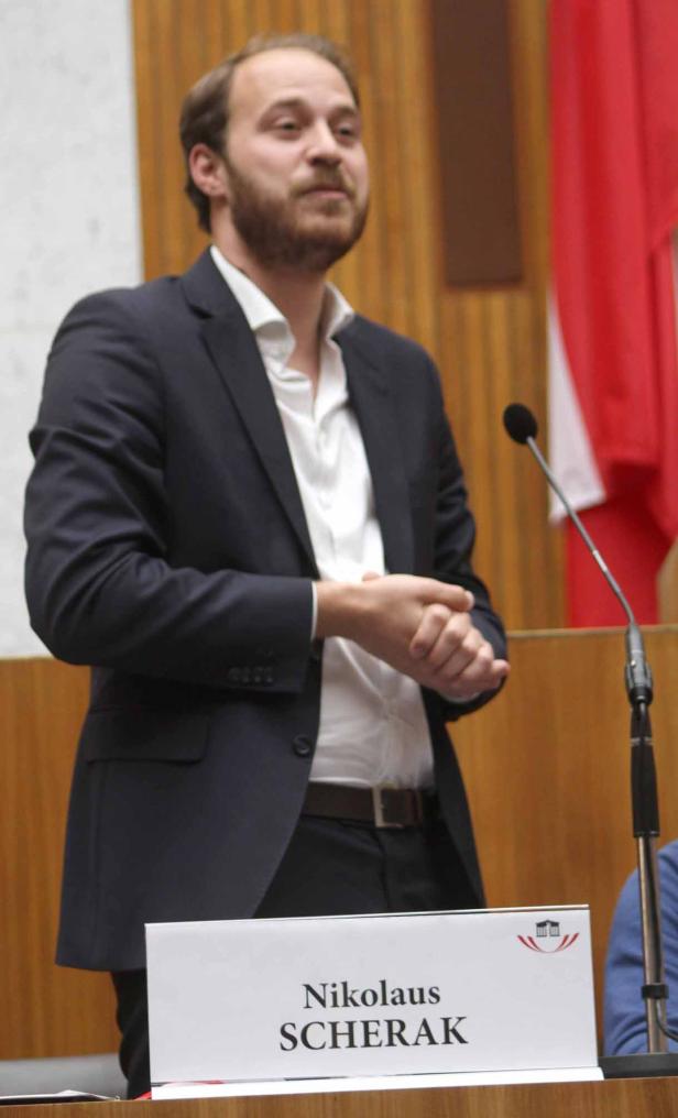 Nikolaus Scherak bei einer Rede vor einem Mikrofon.