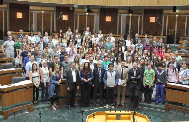 Eine große Gruppe von Menschen steht im österreichischen Parlament in Wien.