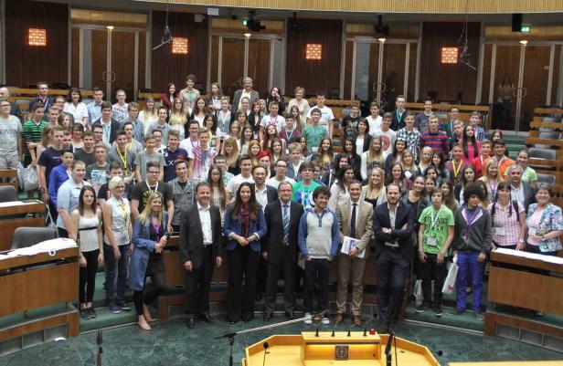 Eine große Gruppe von Menschen steht in einem Konferenzraum für ein Gruppenfoto.