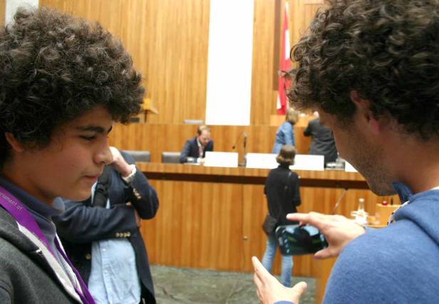 Zwei junge Männer im österreichischen Parlament, einer macht ein Foto.