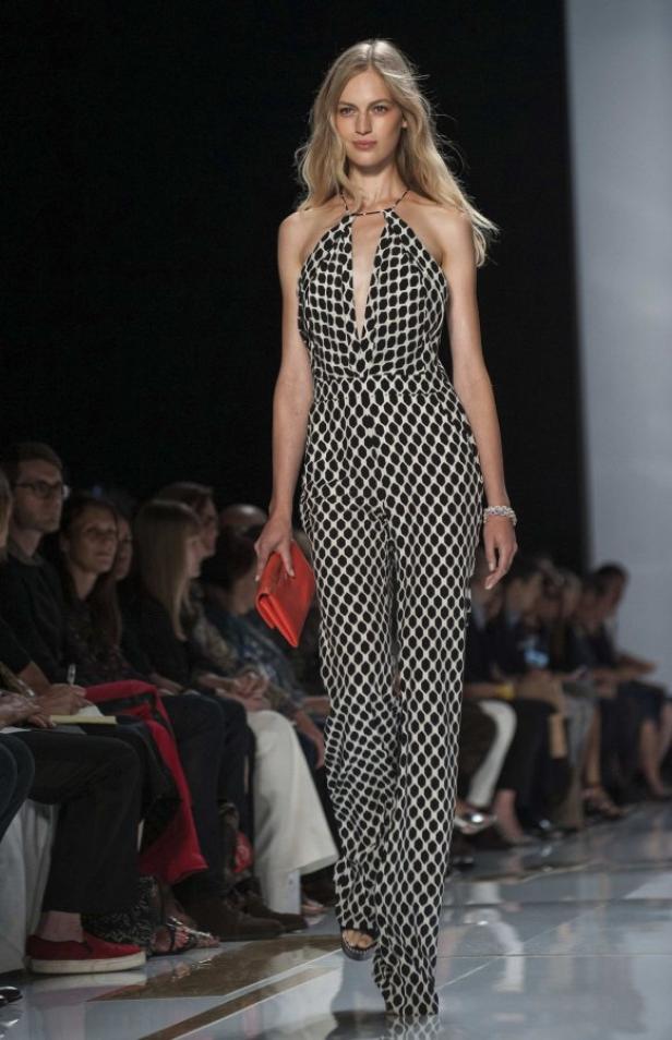 Eine Frau in einem schwarz-weißen Overall mit Muster auf einem Laufsteg.