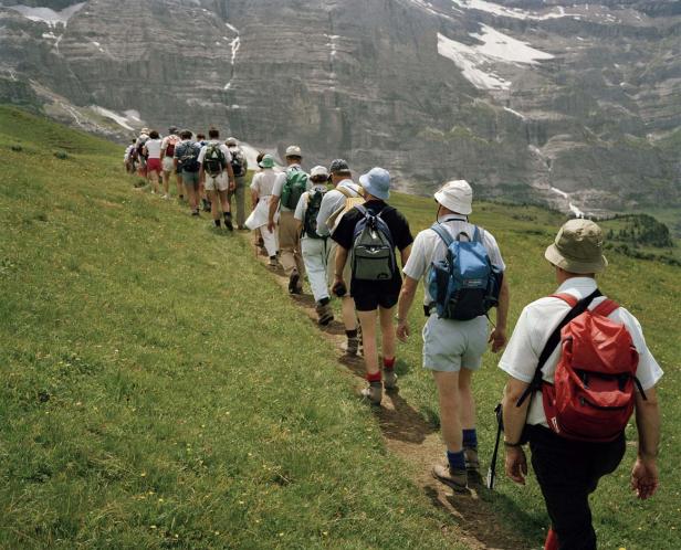 Eine Gruppe Wanderer geht einen Pfad in den Bergen entlang.
