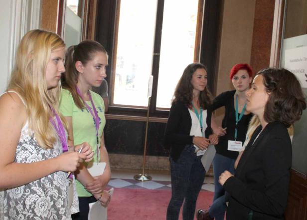 Eine Gruppe junger Frauen steht in einem Raum und unterhält sich.