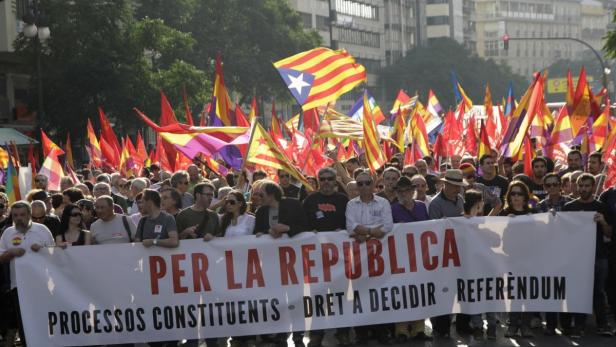 Eine Menschenmenge demonstriert mit katalanischen Flaggen und einem Banner „Per la Republica“.