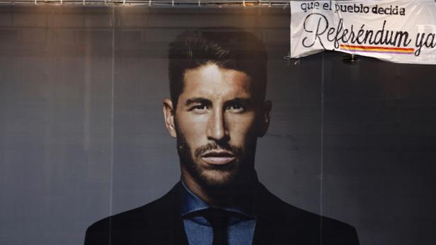 Ein Porträt von Sergio Ramos vor einem Banner, das ein Referendum fordert.