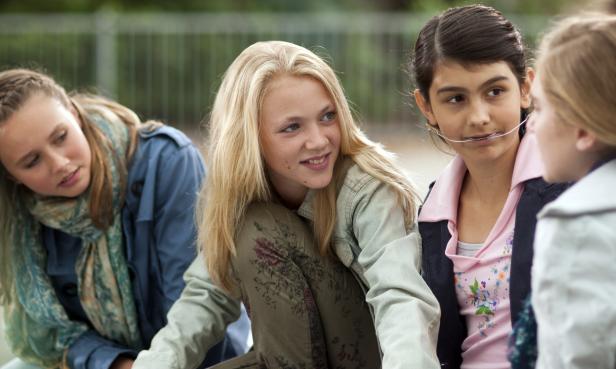 Vier junge Mädchen sitzen zusammen und unterhalten sich.