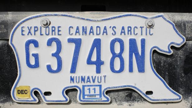 Ein Nummernschild von Nunavut in Form eines Eisbären mit der Aufschrift „Explore Canada's Arctic“.