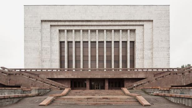 Die Fassade eines großen Gebäudes mit vielen Fenstern und breiten Treppen.