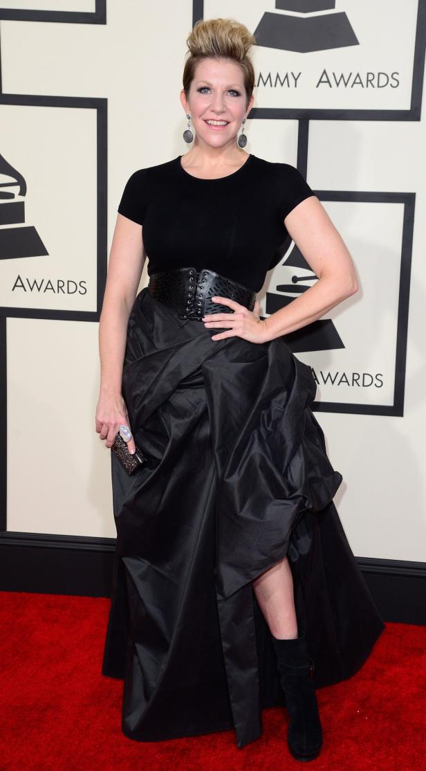 Eine Frau in einem schwarzen Kleid posiert auf dem roten Teppich der Grammy Awards.