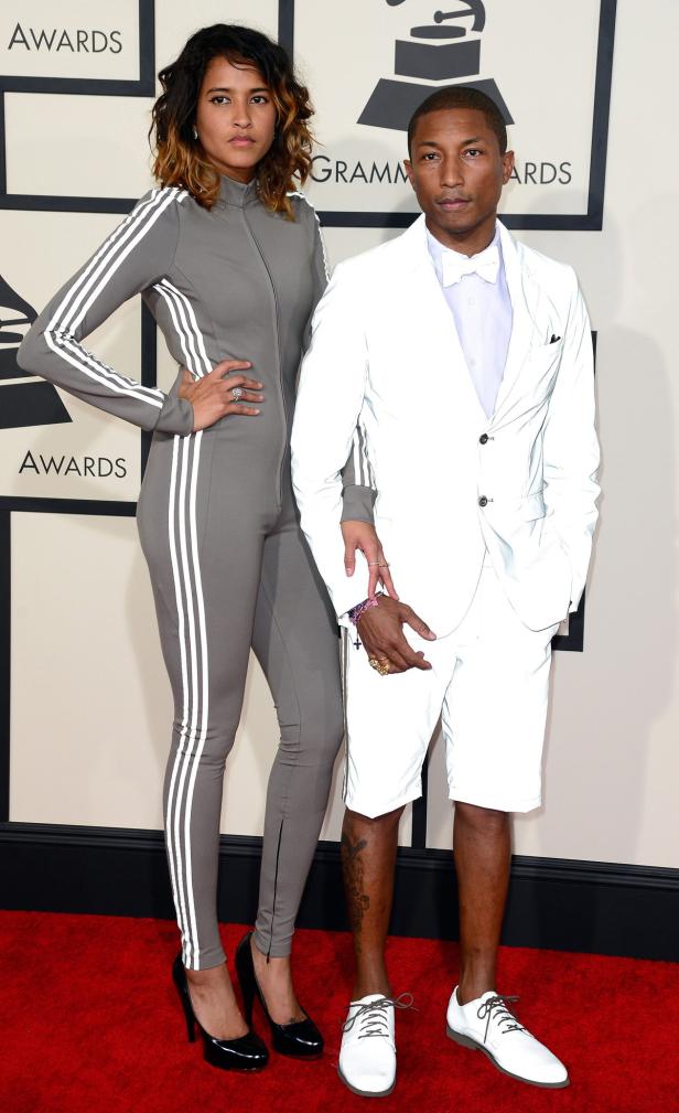 Pharrell Williams und eine Frau posieren auf dem roten Teppich bei einer Preisverleihung.