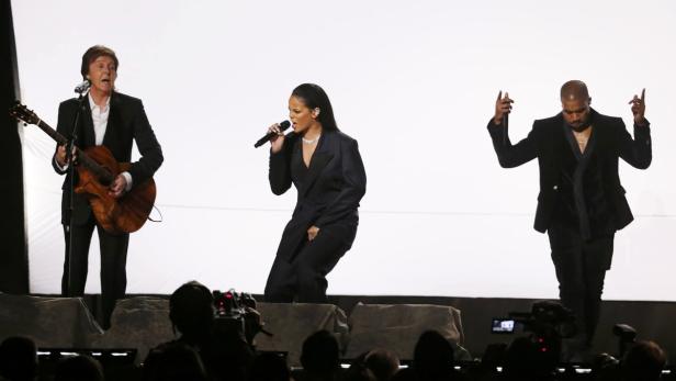 Paul McCartney, Rihanna und Kanye West stehen auf einer Bühne und performen.