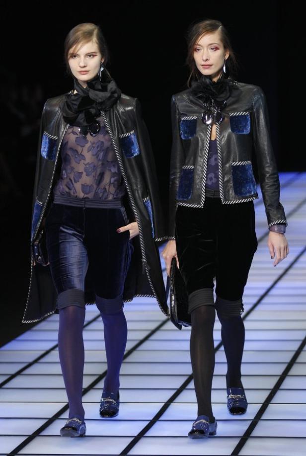 Zwei Models präsentieren eine Kollektion mit Jacken und Shorts auf einem Laufsteg.