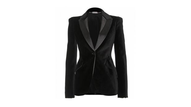 Ein schwarzer Samtblazer mit steigendem Revers vor einem weißen Hintergrund.