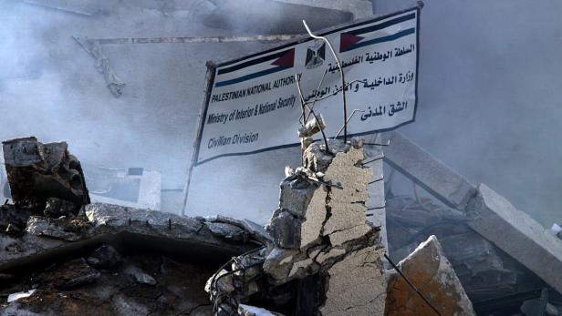 Ein Schild des palästinensischen Innenministeriums steht inmitten von Trümmern.