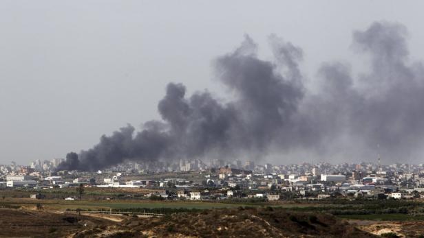 Über einer Stadt steigt dunkler Rauch auf.