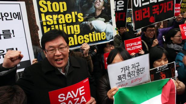 Menschen demonstrieren mit Schildern, die zum Stopp der Tötung von Palästinensern aufrufen.