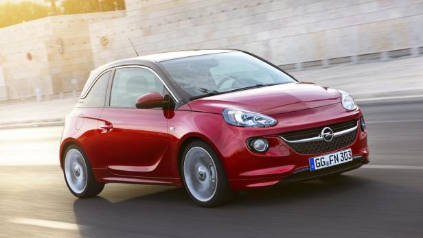 Ein roter Opel Adam fährt auf einer Straße.