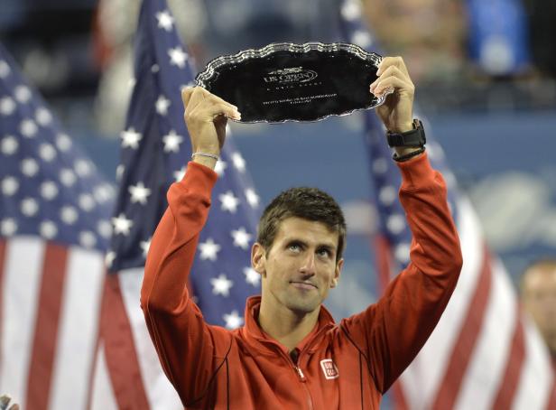 Novak Đoković hält die Trophäe der US Open in die Höhe.