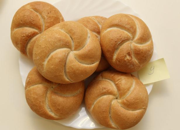 Mehrere Kaisersemmeln liegen auf einem weißen Teller.