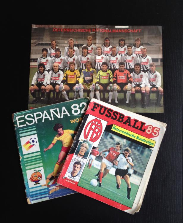 Ein Gruppenfoto der österreichischen Nationalmannschaft mit zwei Fußballbüchern, „España 82“ und „Fussball 85“.