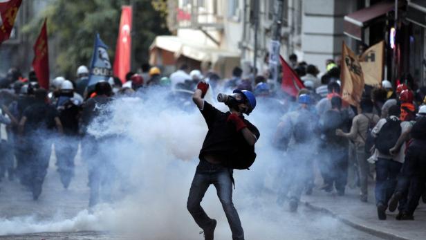 TURKEY POLITICS PROTEST Ein Demonstrant wirft inmitten einer Menschenmenge eine Rauchgranate.