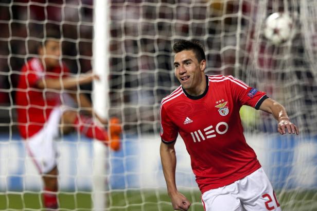 Ein Fußballspieler im roten Trikot von Benfica Lissabon jubelt vor dem Tornetz.