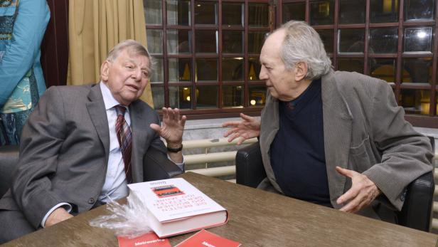 Zwei ältere Herren sitzen an einem Tisch und diskutieren angeregt.